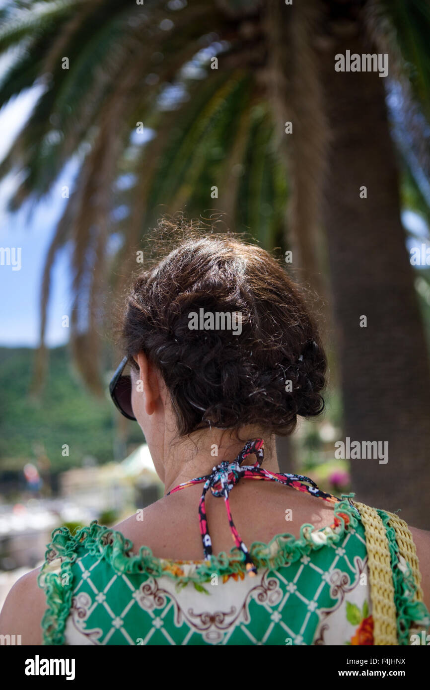 Italien, Rückansicht Braunhaarige Frau mit Palme im Hintergrund Stockfoto