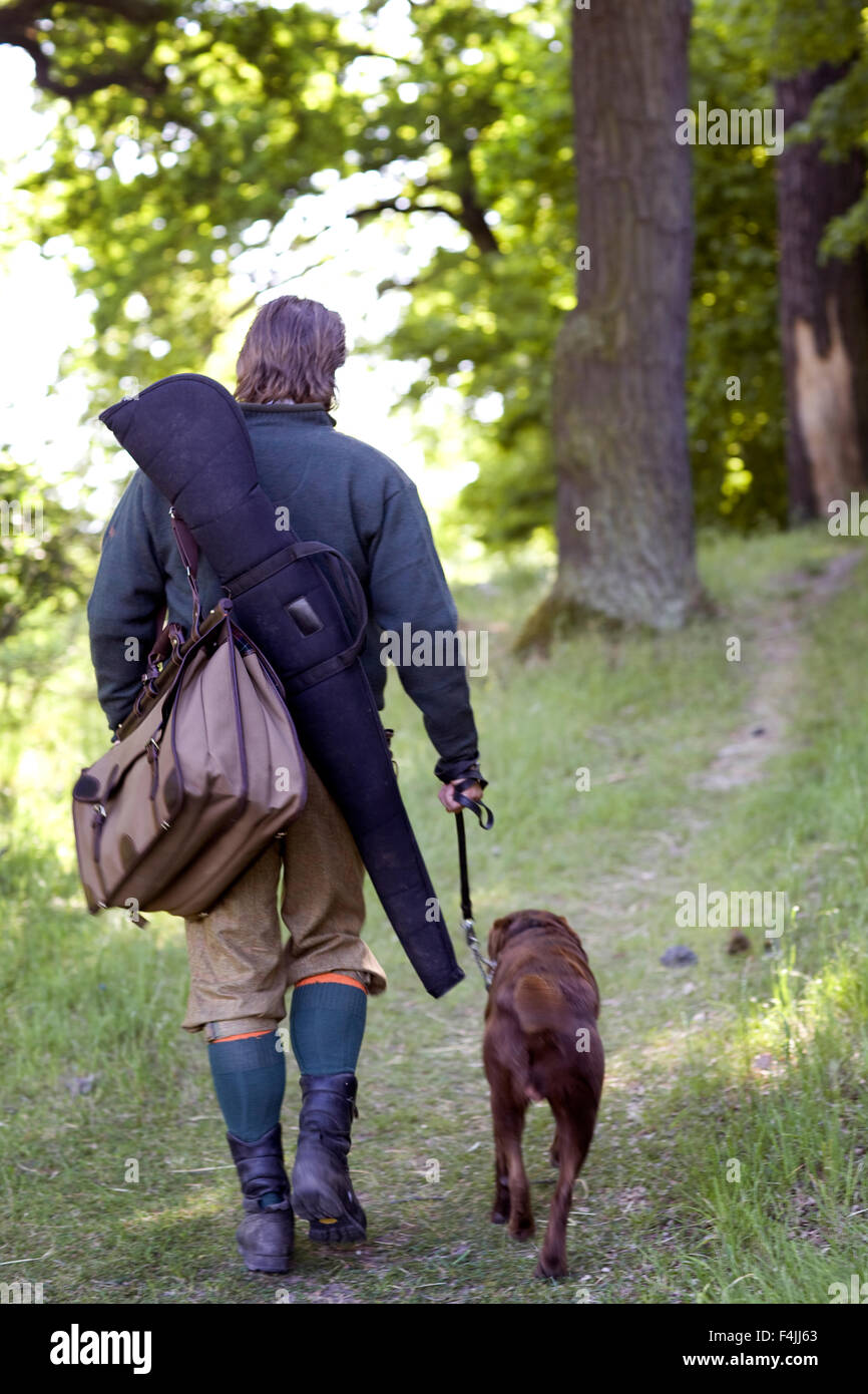 Rückansicht des Mitte erwachsener Mann auf die Jagd mit Hund Stockfoto