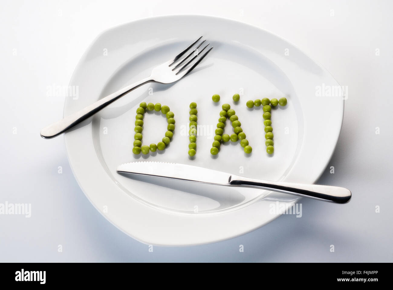 Erbsen, bilden das Wort Diät auf einem Teller mit Besteck. Stockfoto