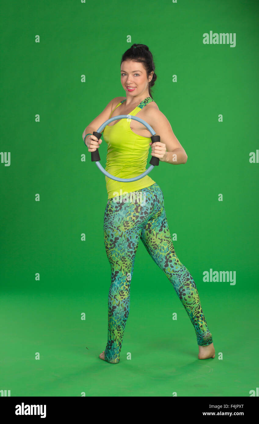 Frau macht Pilates Ring auf grünem Hintergrund Stockfoto