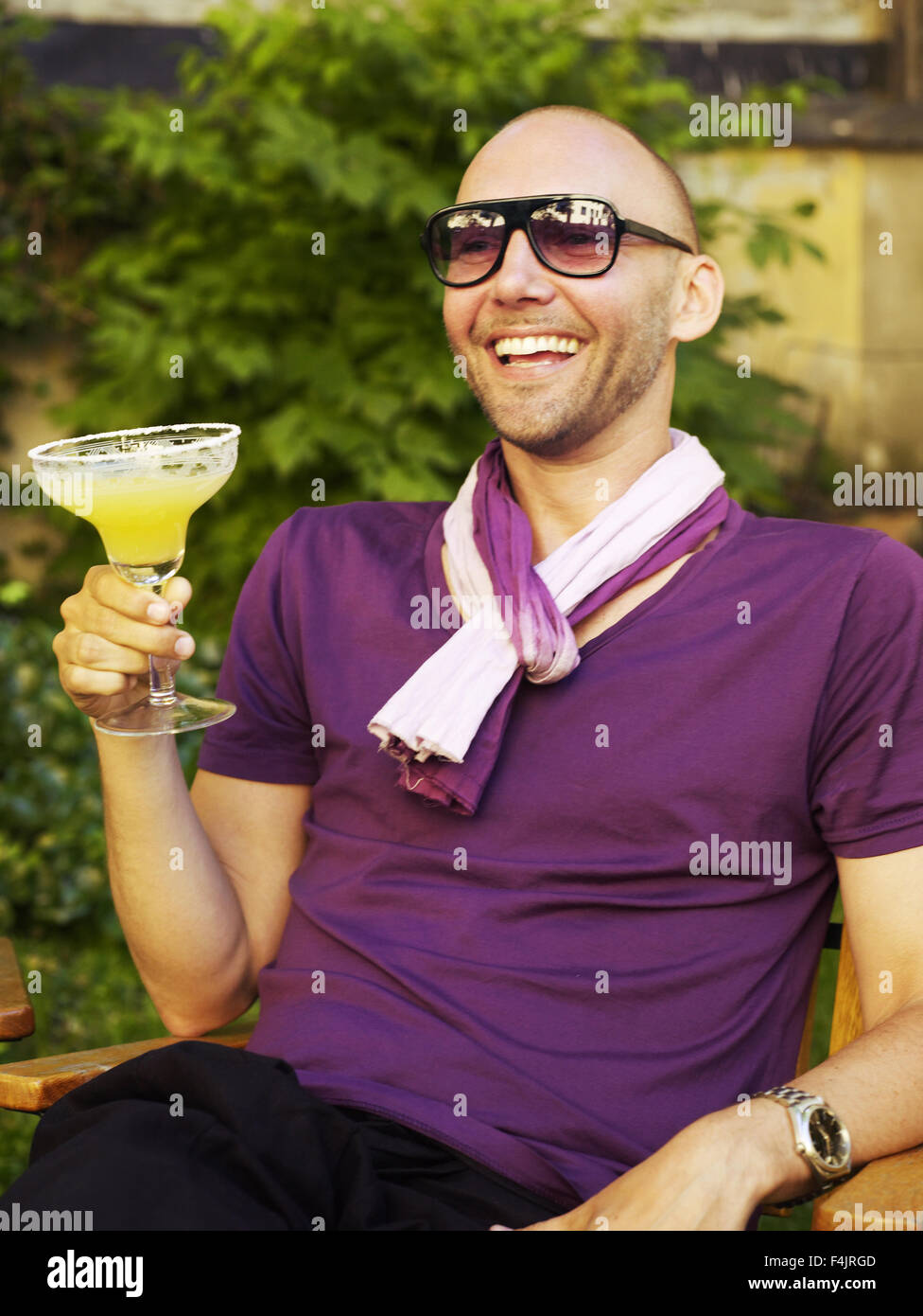 Mitte erwachsenen Mannes Saft zu trinken, im Hinterhof Stockfoto