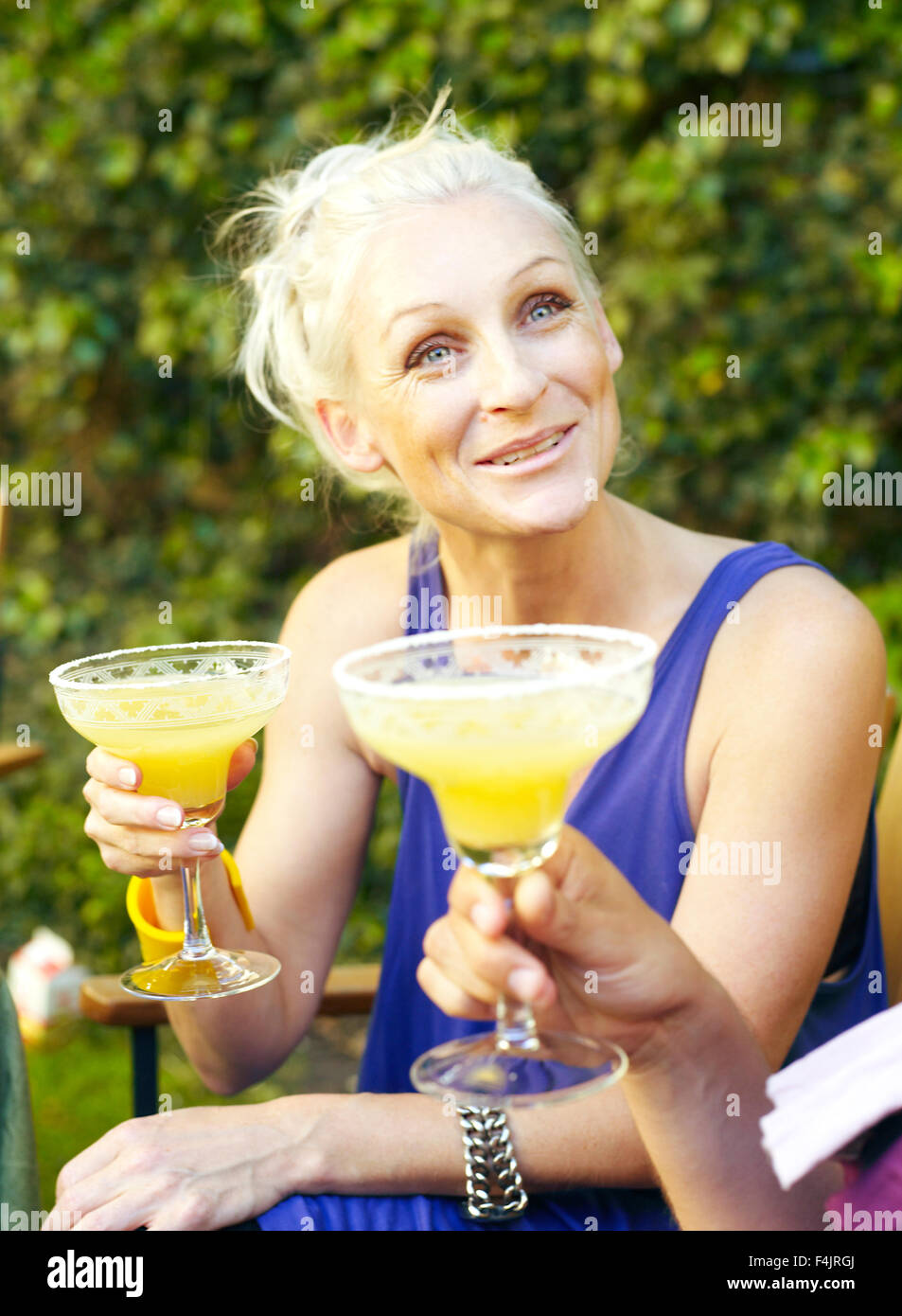 Mitte Erwachsene Frau trinken Saft im Hinterhof Stockfoto