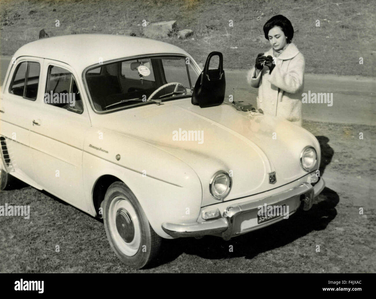 Frau mit weißen Renault Dauphine Auto und schwarze Handtasche, Italien Stockfoto