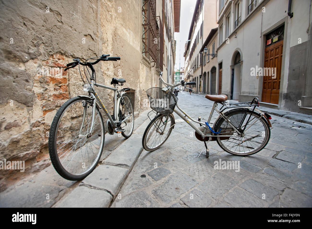 Zwei Fahrräder auf steht in leere Straße geparkt, Florenz Italien, Stockfoto