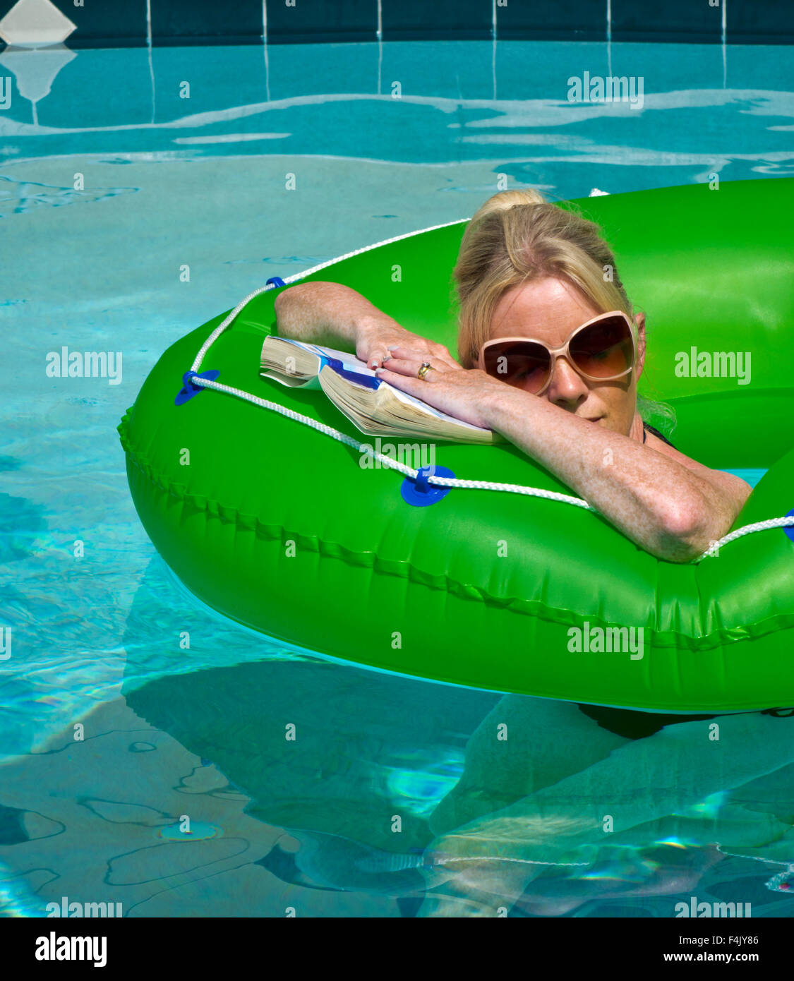Frau im Urlaub entspannen Sie sich auf einen Gummiring in einem pool Stockfoto