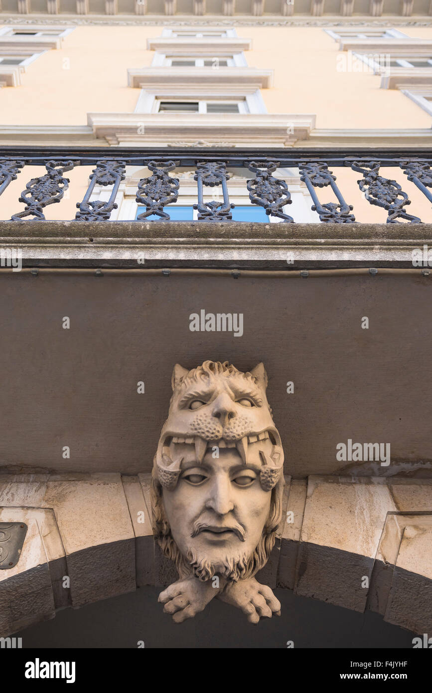 Balkon aus Korbelstein italien, Detail eines Korbelsteins, der einen Kopf mit Leopardenkopfschmuck auf der Piazza del Borsa, Triest, Italien darstellt Stockfoto