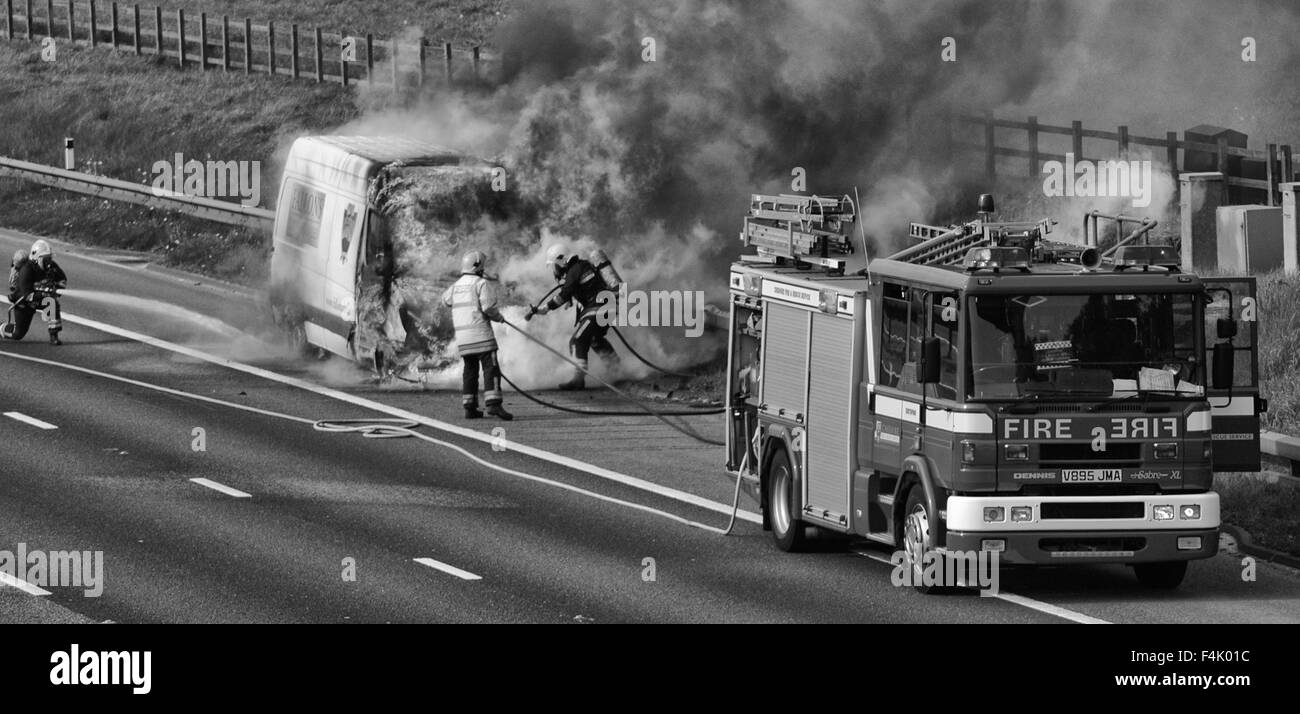 Feuerwehrleute aus einem van Feuer auf der Autobahn Stockfoto