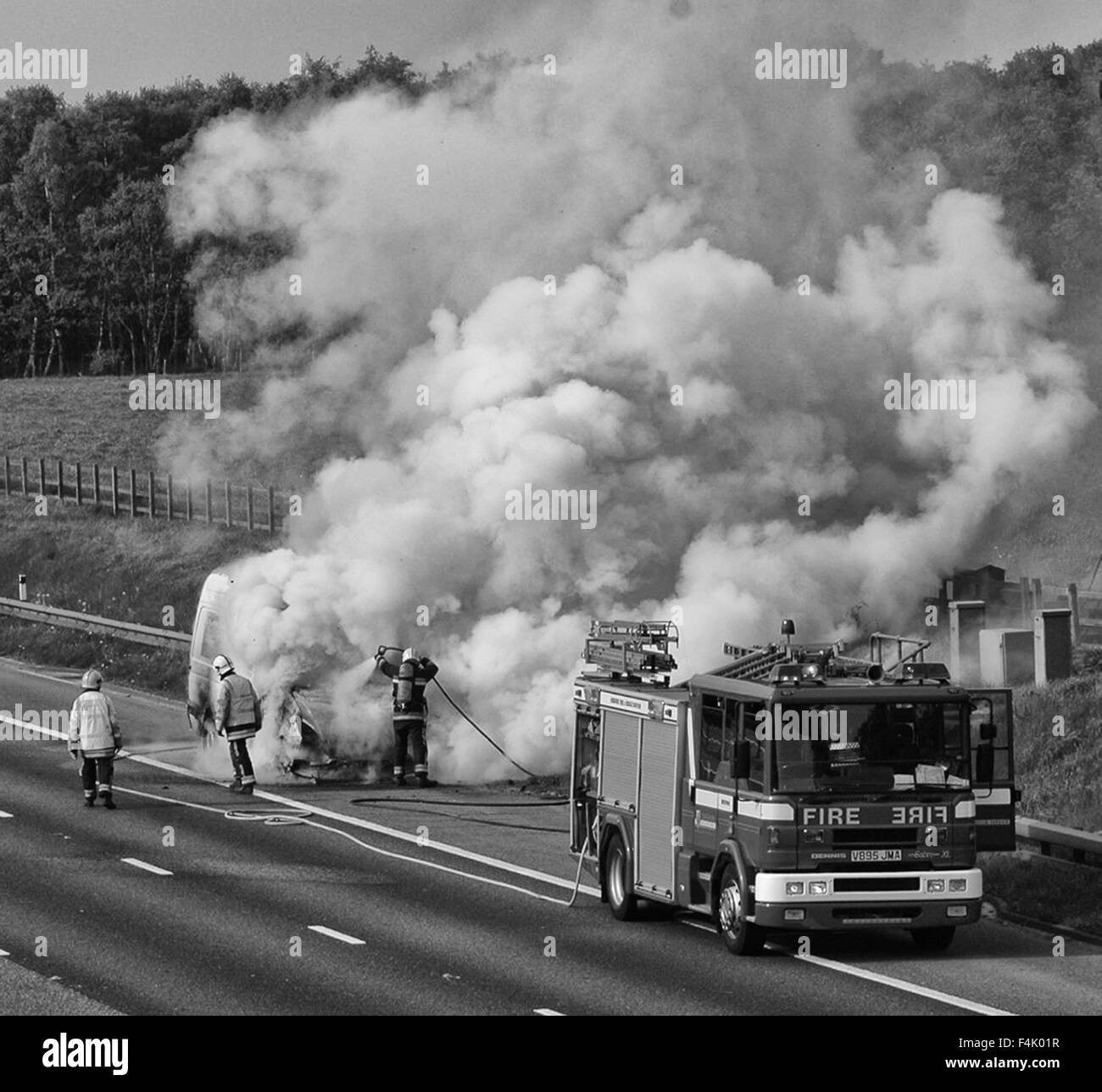 Feuerwehrleute aus einem van Feuer auf der Autobahn Stockfoto