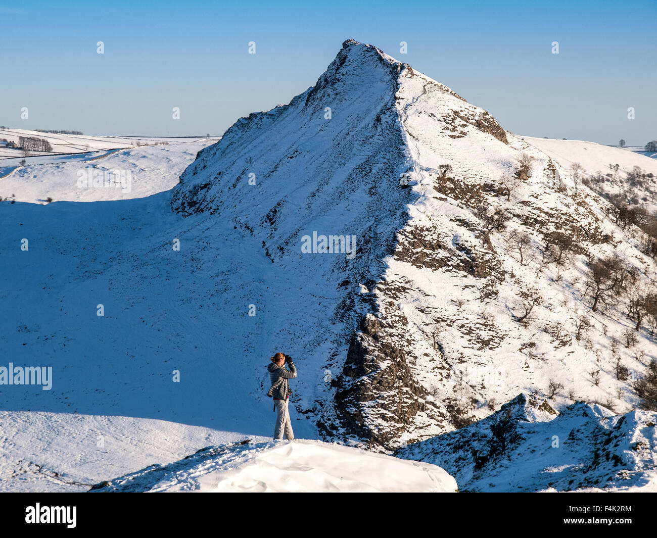 Eine weibliche Walker auf dem verschneiten Grat von Chrome Hügel mit Parkhaus Hügel hinter, Peak District National Park Stockfoto
