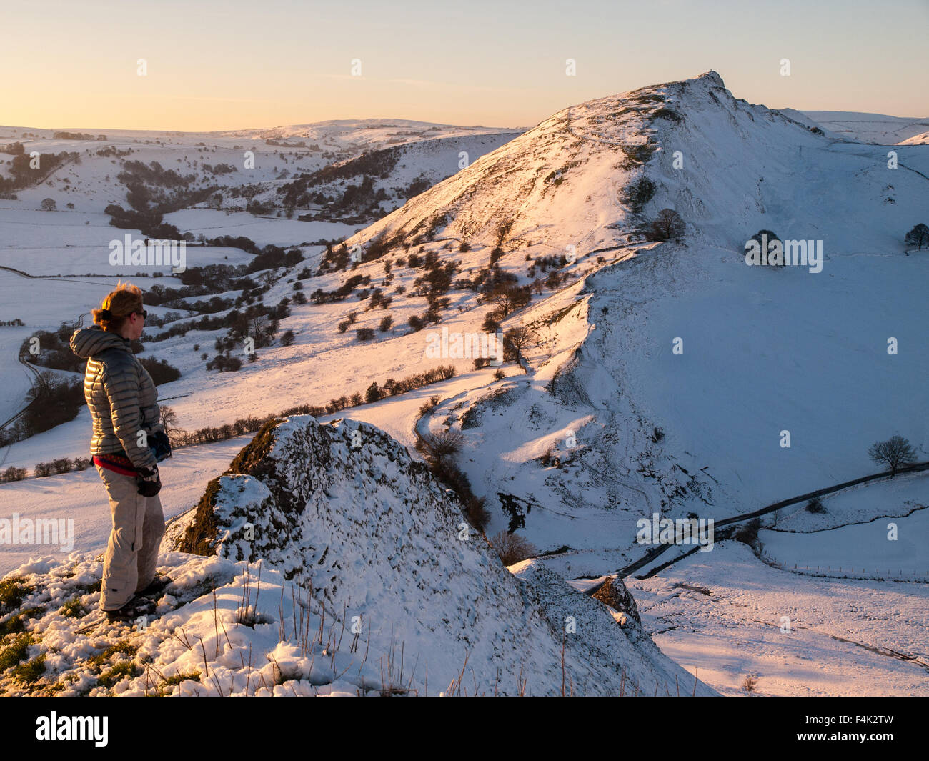 Weibliche Walker auf verschneiten Parkhouse Hill im oberen Taube Tal, Peak District mit Chrom-Hügel im Abstand Stockfoto