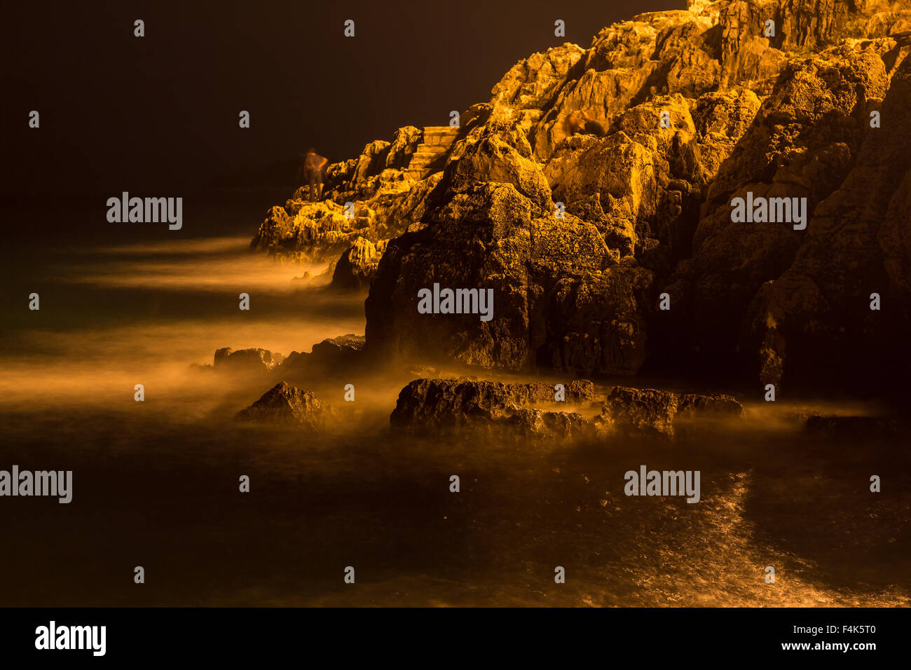 Meereswellen lash Linie Auswirkungen Felsen am Strand bei Nacht Stockfoto