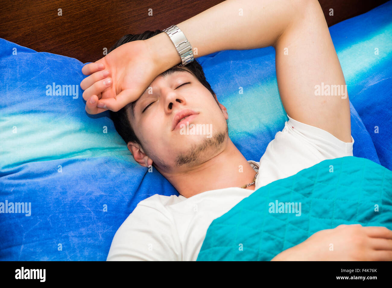 Schönen jungen krank oder unwohl Mann im Bett mit einer Grippe oder Fieber Stockfoto