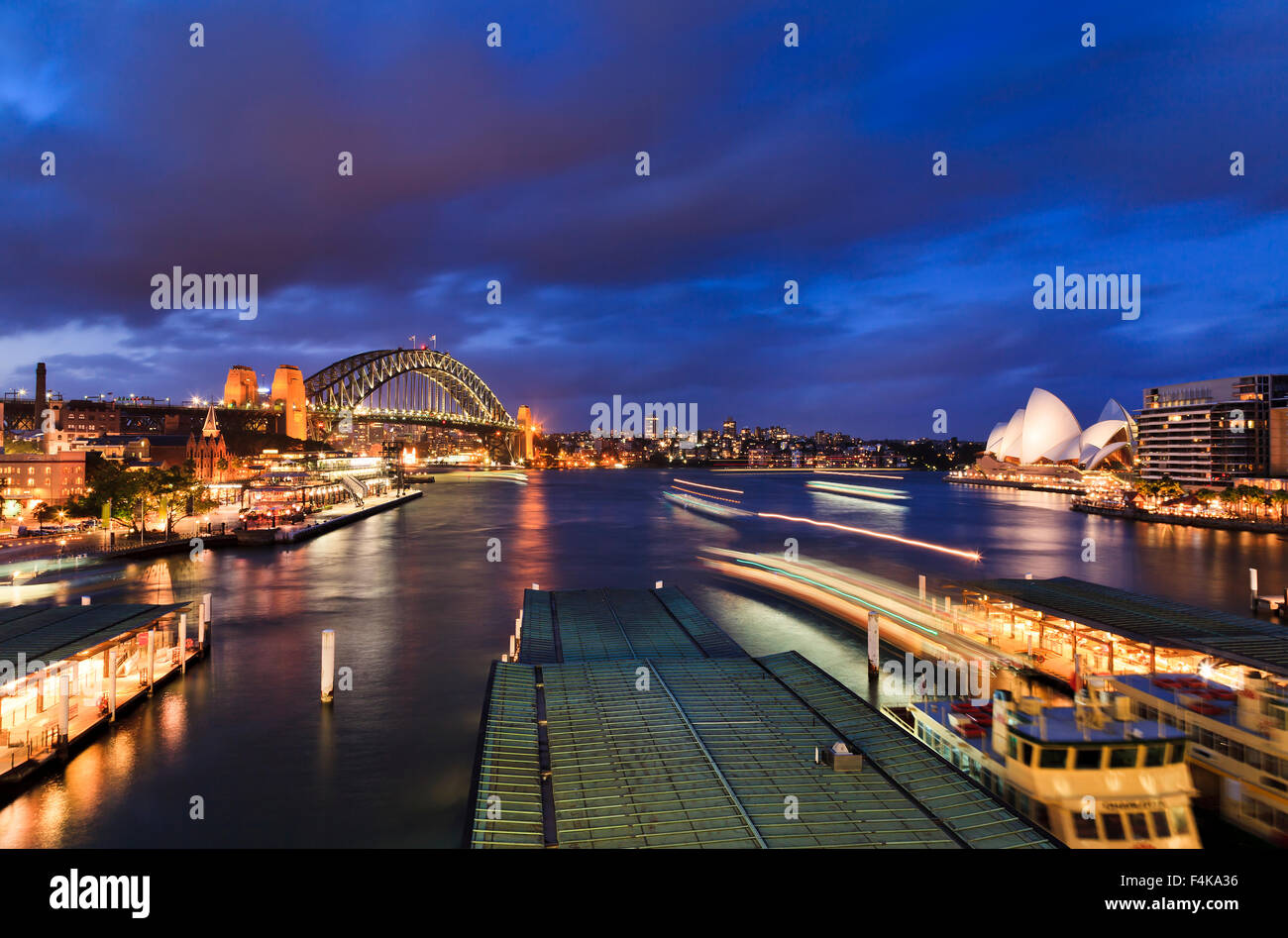 Australien Sydney Großstadt Wahrzeichen - circular Quay bei Sonnenuntergang Blick auf die Harbour Bridge und Passagierfähren Stockfoto