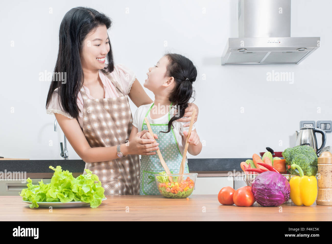 Familie, Kinder und glückliche Menschen Konzept - Asiatisch Kochen in der Küche zu Hause Tochter von Mutter und Kind Stockfoto