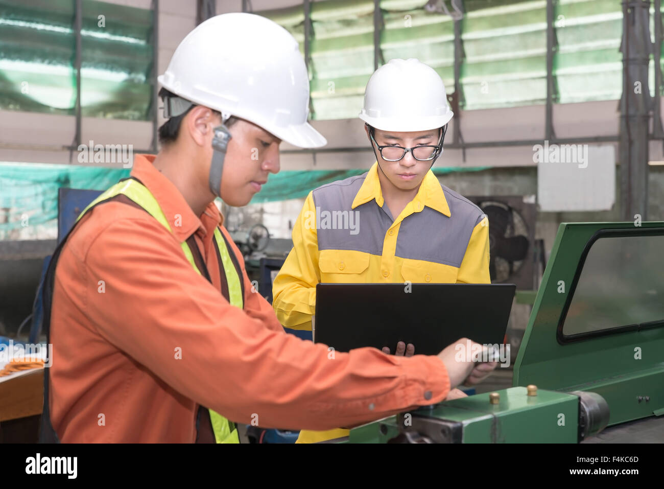 Asiatische Maschinenbau-Ingenieur mit CAD-Planung und Steuerung Ausrüstung im Werk zu tun Stockfoto
