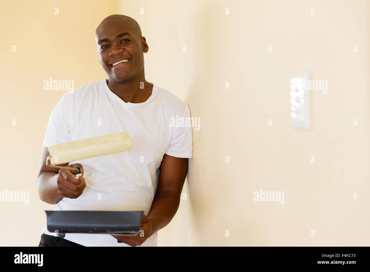 hübscher afroamerikanische Mann Malerei Wand zu Hause Stockfoto