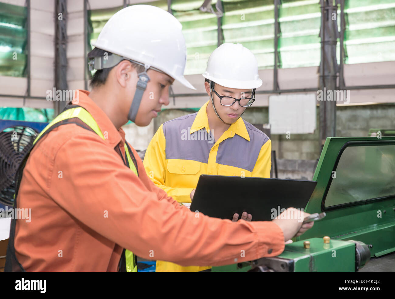 Asiatische Maschinenbau-Ingenieur mit CAD-Planung und Steuerung Ausrüstung im Werk zu tun Stockfoto