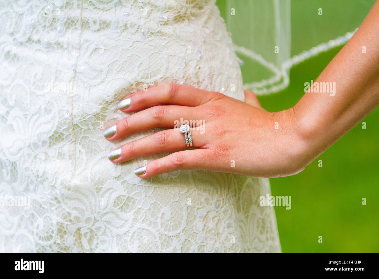 Hand der Braut auf ihre Hüften mit Hochzeitskleid und Ring angezeigt. Stockfoto