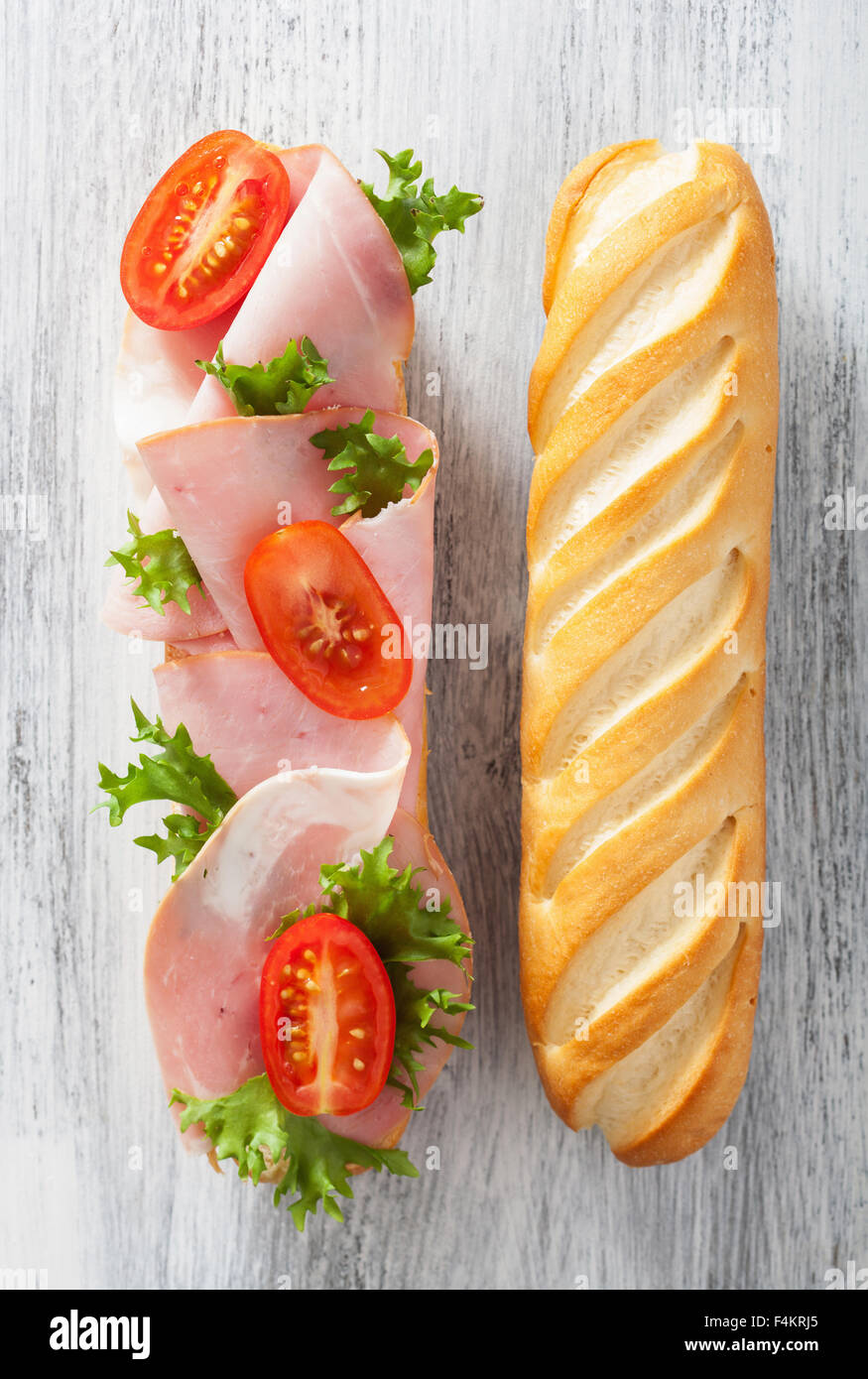 langes Baguette-Sandwich mit Schinken-Tomaten-Salat Stockfoto
