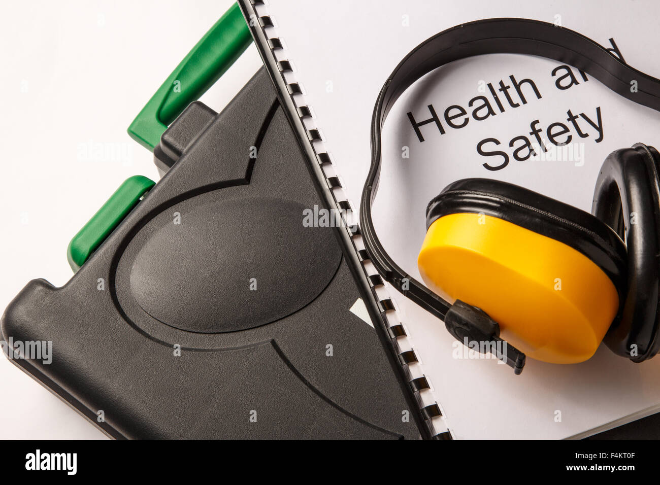 Schwarz-Toolbox mit Kopfhörern und Dokument zu Gesundheitsschutz und Sicherheit Stockfoto