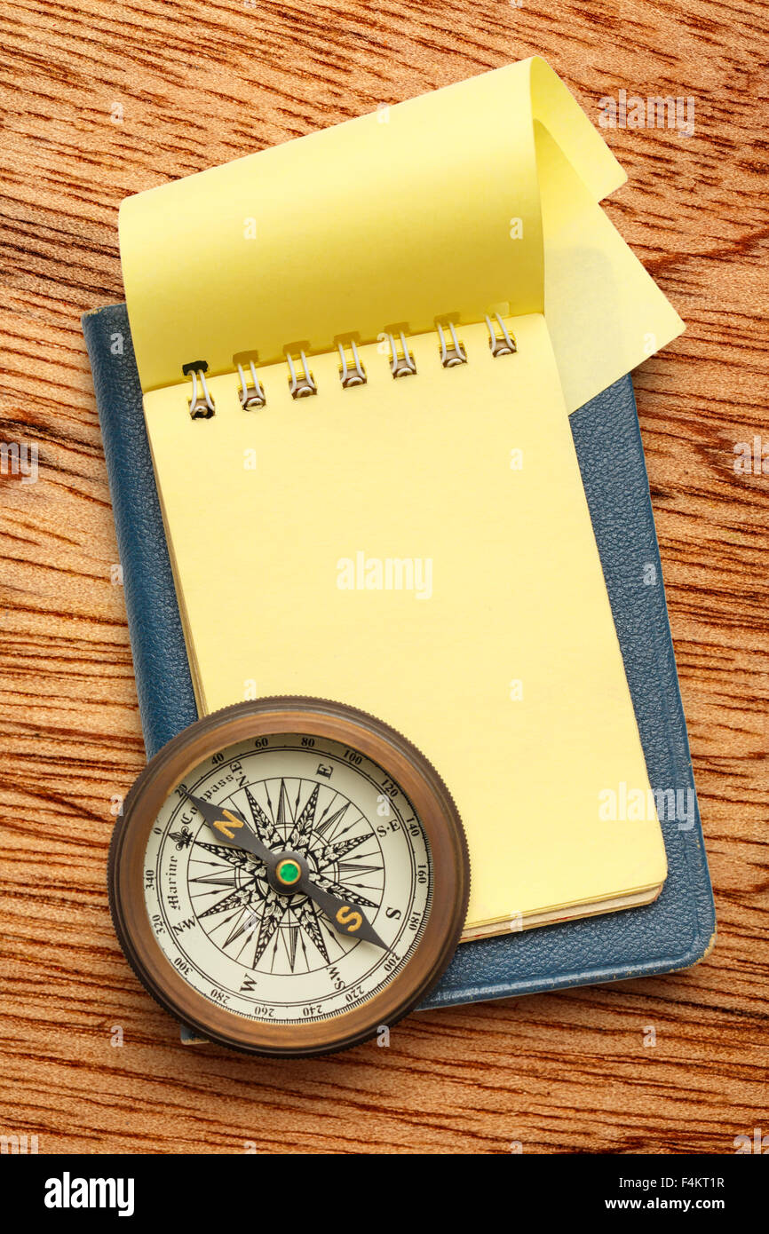 Vintage Kompass und leeren gelben Notizblock geöffnet Stockfoto