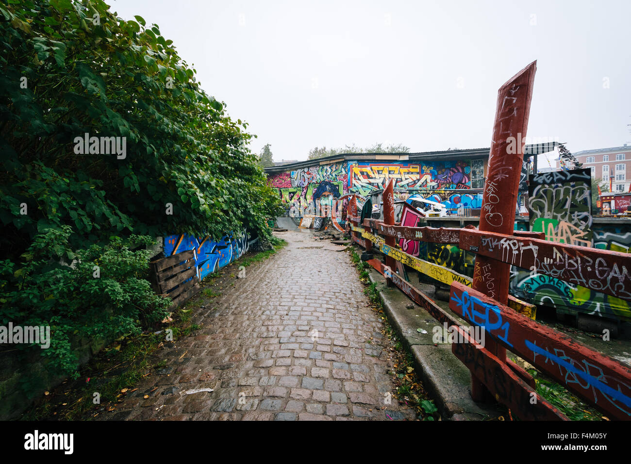 Graffiti auf auf einen Zaun und Gebäude in Christiania, in Christianshavn, Kopenhagen, Dänemark. Stockfoto