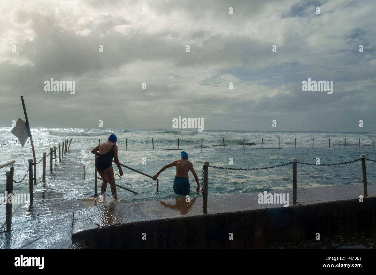 Ein älteres Paar schwimmen in Newport Beach Ocean Pool in rauher See am frühen Morgen in Sydney, Australien Stockfoto