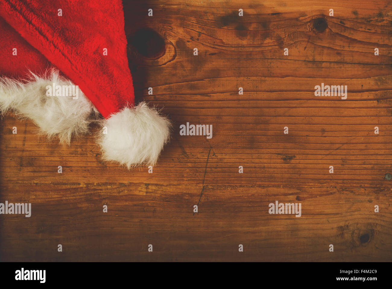 Retro-getönten Weihnachtsmann Hut auf Schreibtisch aus Holz mit leeren Textfreiraum, Ansicht von oben Stockfoto
