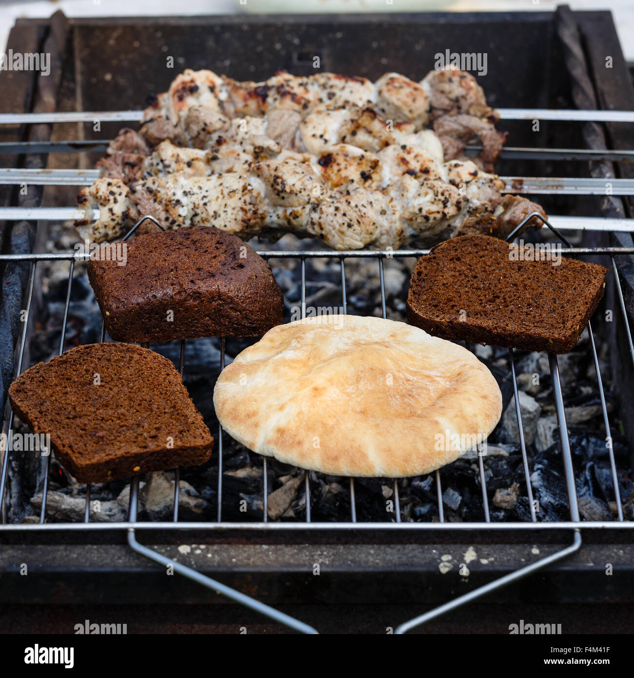 Fladen, Scheiben Graubrot und Schaschlik vom Fleisch auf einem Kohlenbecken erwärmt Stockfoto