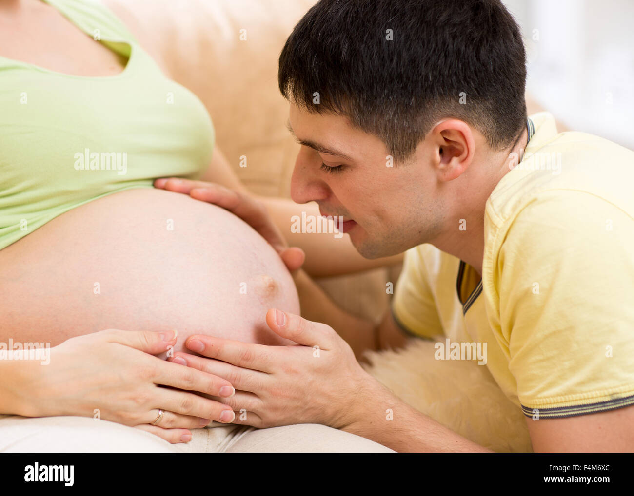 Zukünftige Vater betrachtet man schwangeren Bauch seiner schwangeren Frau Stockfoto