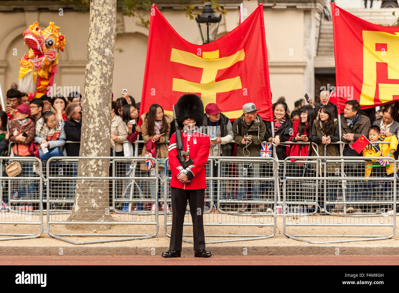 London, UK.  20. Oktober 2015.  Eine Königin Wache Mitglied steht stramm wie Massen warten, bis der chinesische Präsident Xi Jinping, über The Mall auf dem Weg zum Buckingham Palace, während seines Staatsbesuchs in das Vereinigte Königreich Reisen zu sehen.  Bildnachweis: Stephen Chung / Alamy Live News Stockfoto