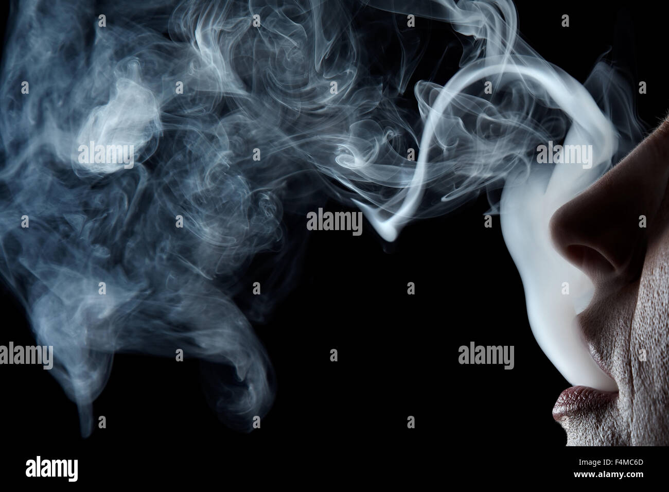Mund ausatmen Zigarettenrauch auf schwarzem Hintergrund Stockfoto