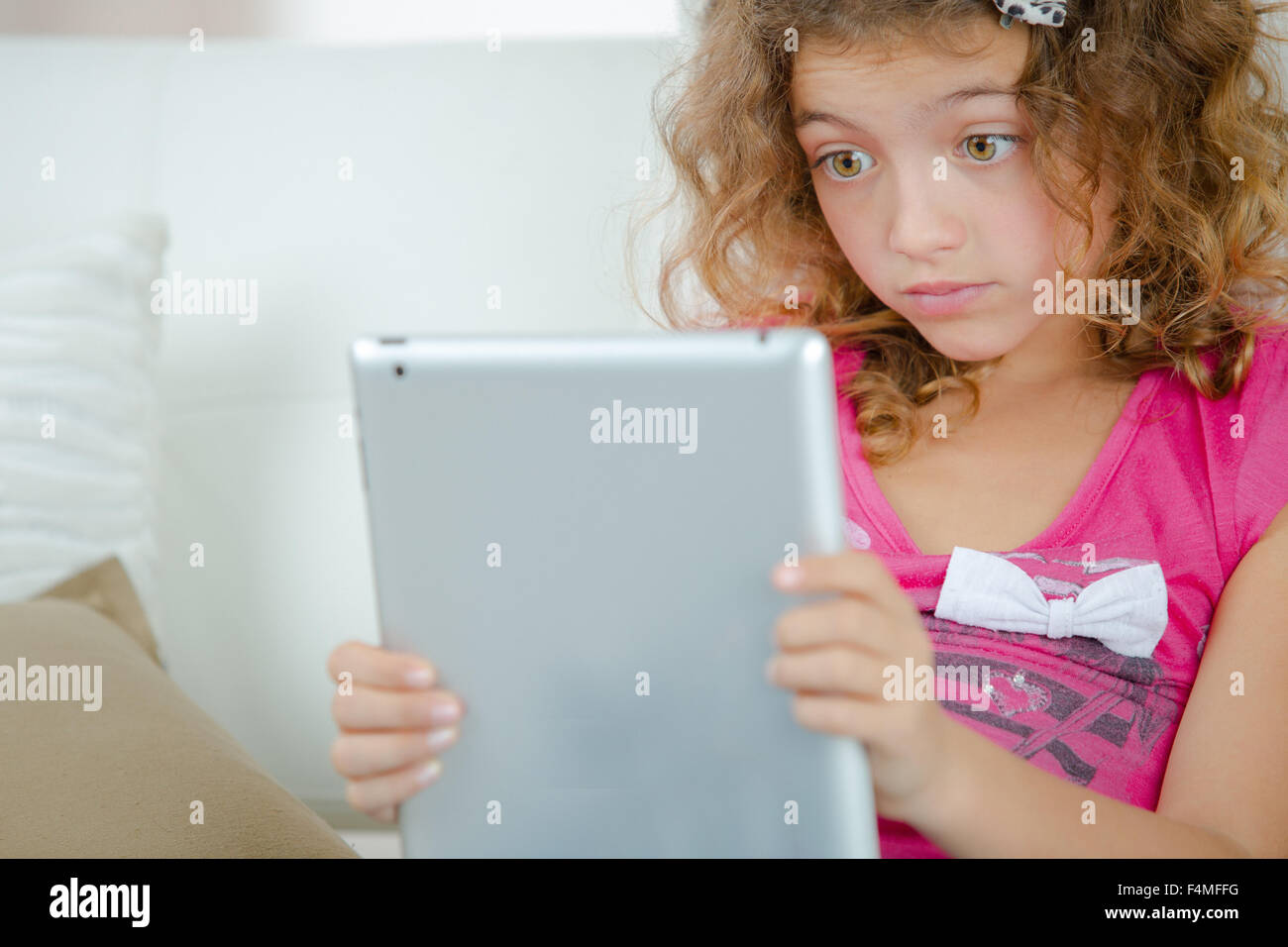 Schulmädchen mit schockiert Ausdruck Blick auf tablet Stockfoto