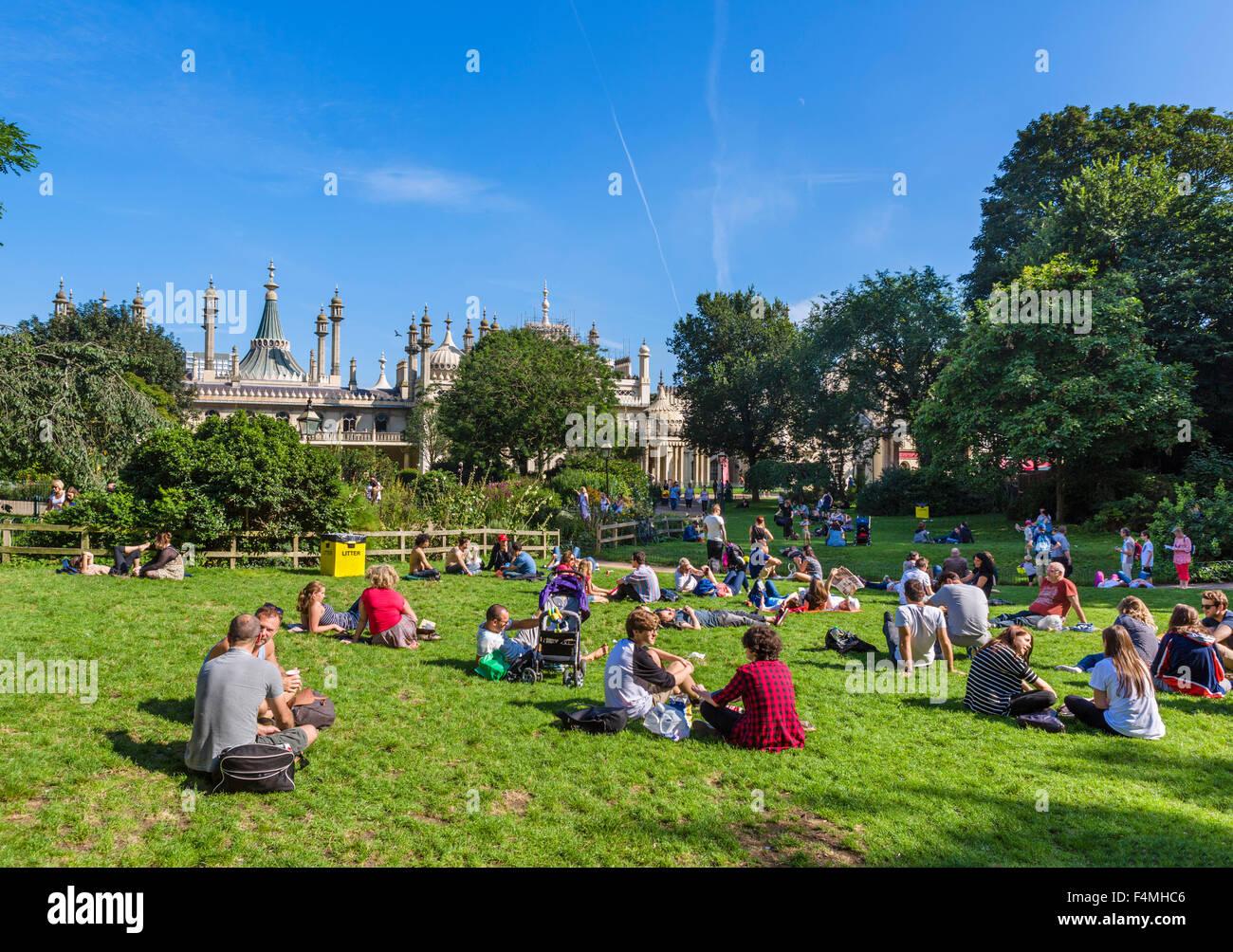 Brighton, East Sussex.Young Menschen sitzen auf dem Rasen vor dem Royal Pavilion, Brighton, East Sussex, England, UK Stockfoto