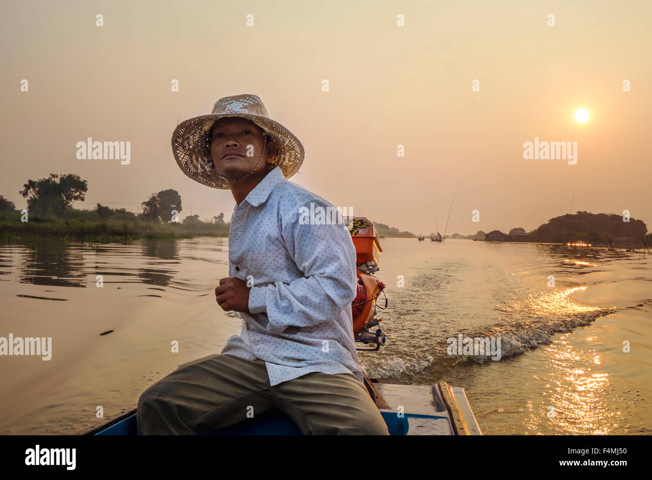 Ein Dorfbewohner steuert sein Boot durch die schwimmenden Dorf von Prek Toal auf See Tonle Sap. Stockfoto
