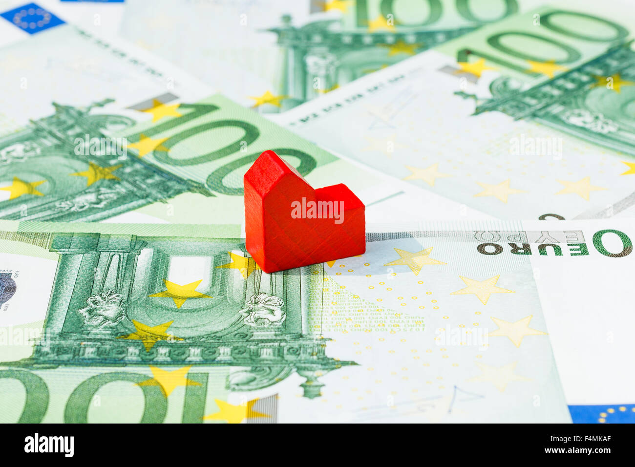 Konzept Haus verkaufen, Abschottung, Schulden, Bill, Hypothek auf hundert Euro-Banknoten. Rotes Haus im Mittelpunkt. Stockfoto