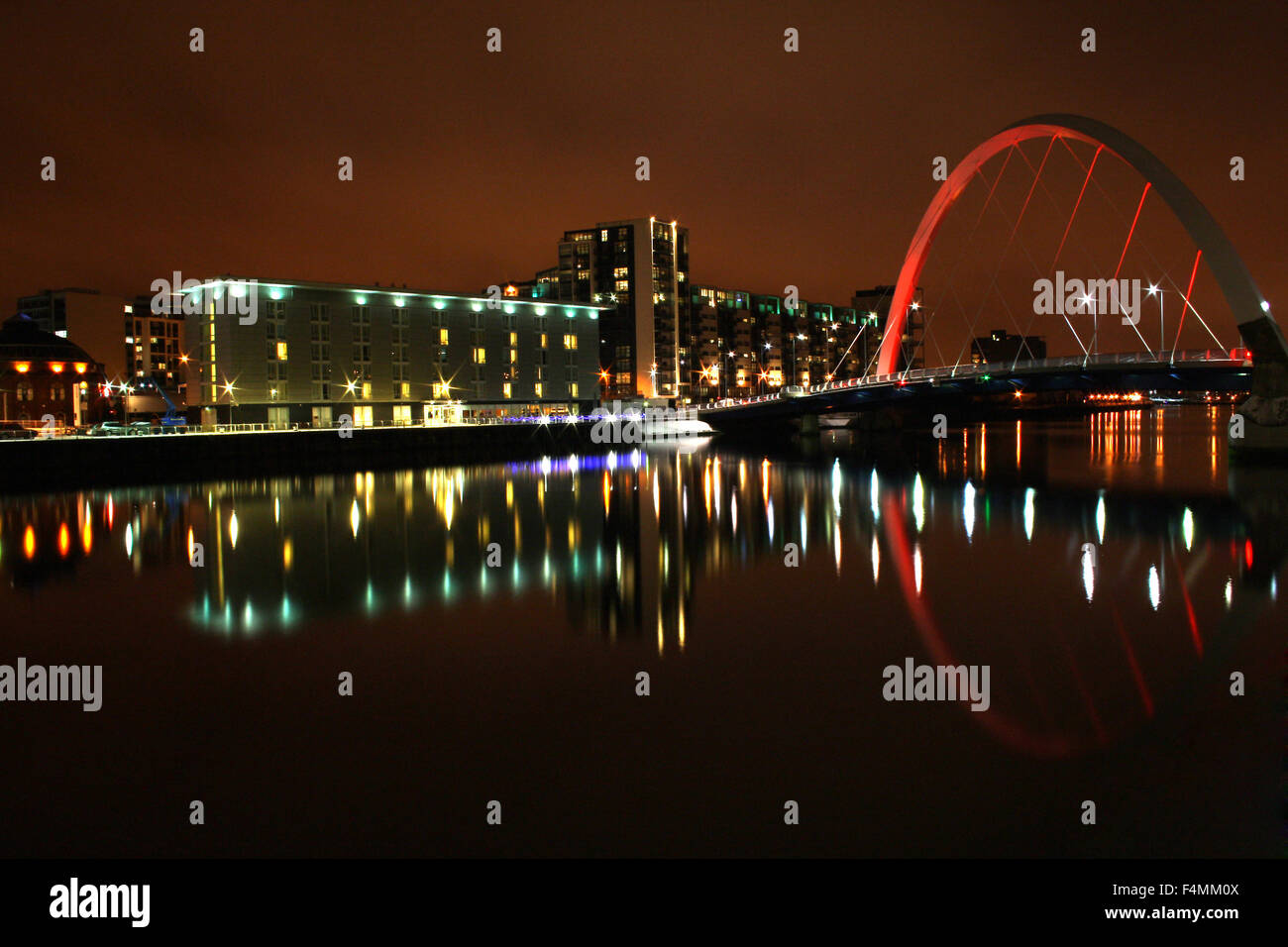 Glasgow Clyde Arc Brücke, auch bekannt als Finnieston, mit Reflexionen im Fluss Clyde in der Nacht. Stockfoto