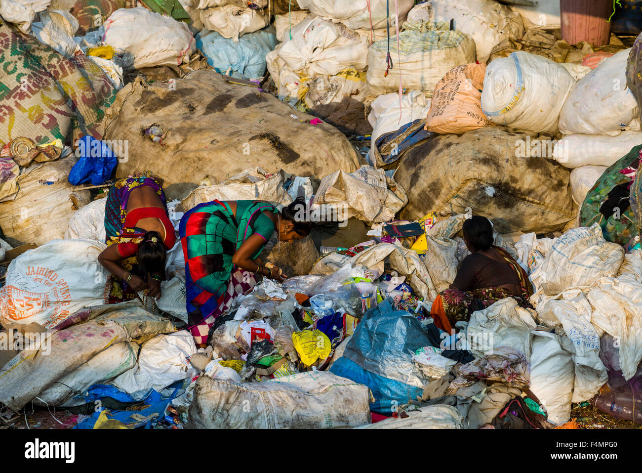 Zwei Frauen in bunten Saris sind Aussortieren Müll. Etwa 10.000 Arbeitskräfte arbeiten in 800 kleinen Unternehmen, die hauptsächlich in der Tracht Stockfoto