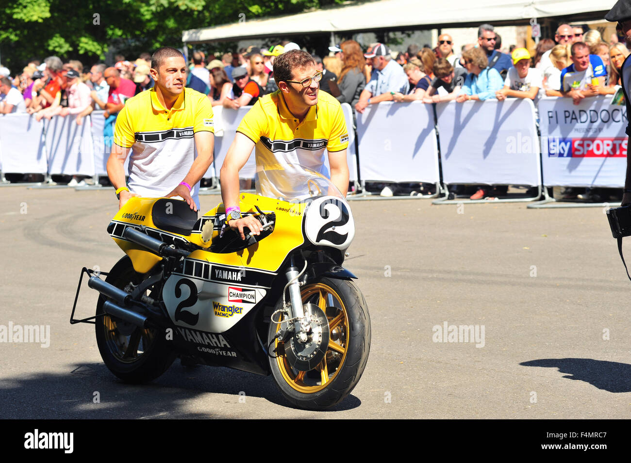 Yamaha-Technikern schieben ein Yamaha YZR750 OW31 Rennrad das Fahrerlager auf dem Goodwood Festival of Speed im Vereinigten Königreich. Stockfoto