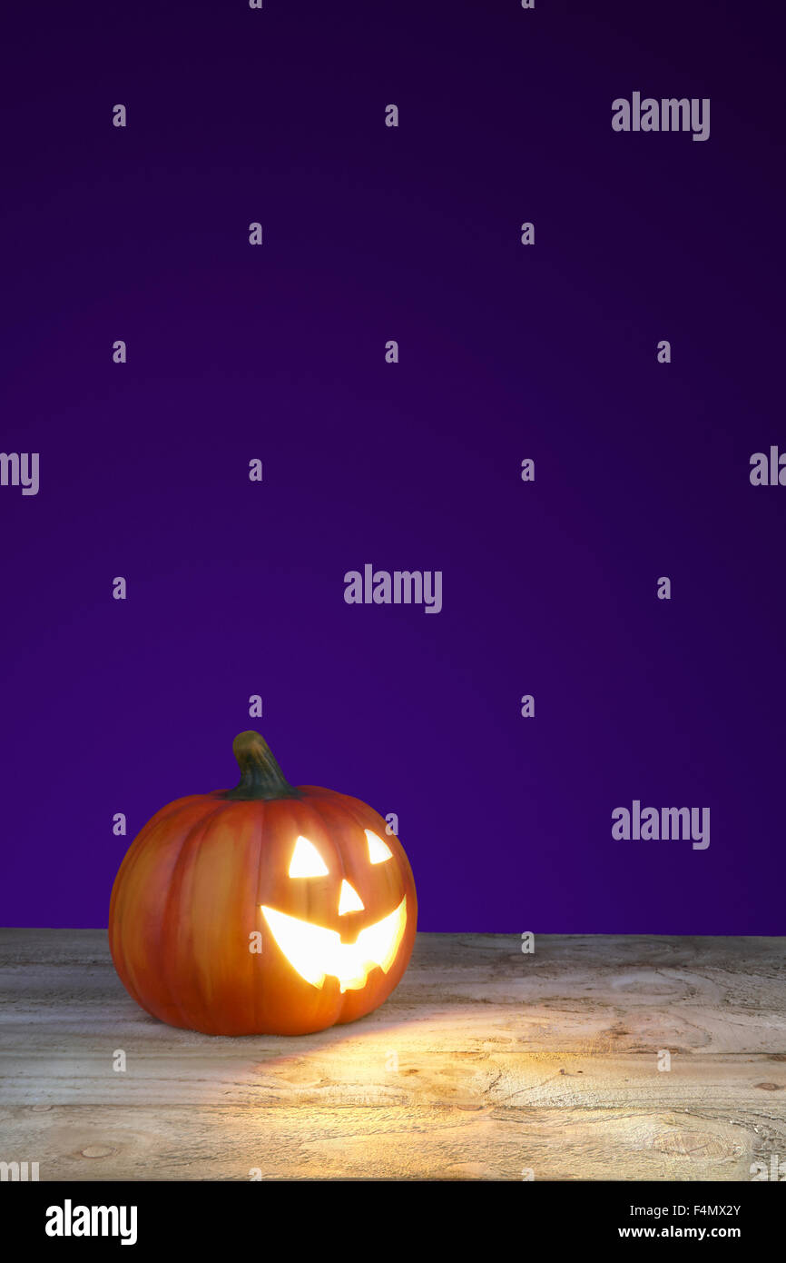 große Halloween Jack o Lantern Kürbis mit einem lila Hintergrund Stockfoto