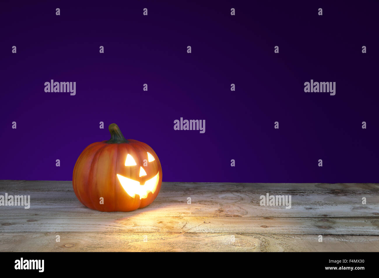 große Halloween Jack o Lantern Kürbis mit einem lila Hintergrund Stockfoto