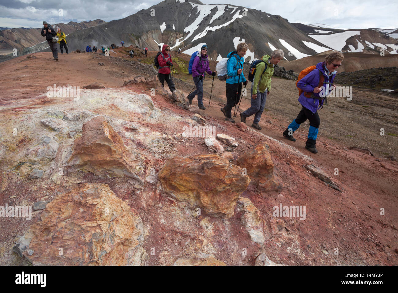 Wanderer vorbei an vulkanischen Mineral Ablagerungen in Landmannalaugar, Sudhurland, Island. Stockfoto