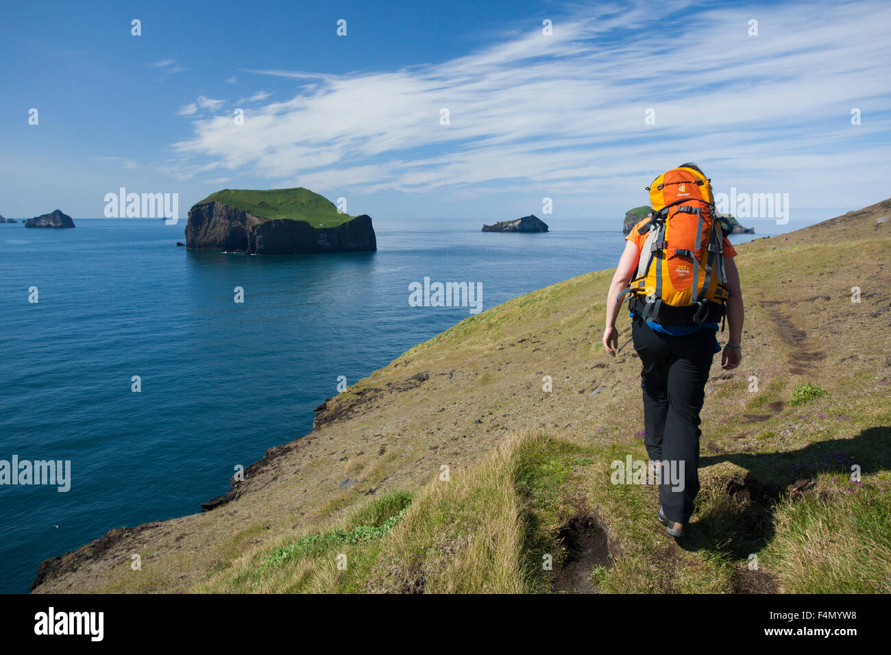 Wanderer vorbei Storhofdi Sudurey Insel von der Halbinsel auf der Insel Heimaey. Westman Inseln, Sudhurland, Island. Stockfoto