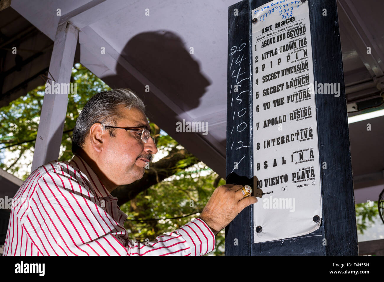 Ein Mann ist, Wetten für ein Pferderennen auf eine Platine mahalaxmi Rennstrecke in der Vorstadt mahalaksmi Stockfoto