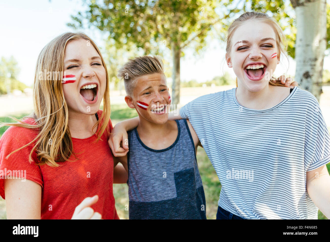 Österreich, drei Jugendliche mit nationalen Farben gemalt auf ihren Wangen gemeinsam feiern Stockfoto
