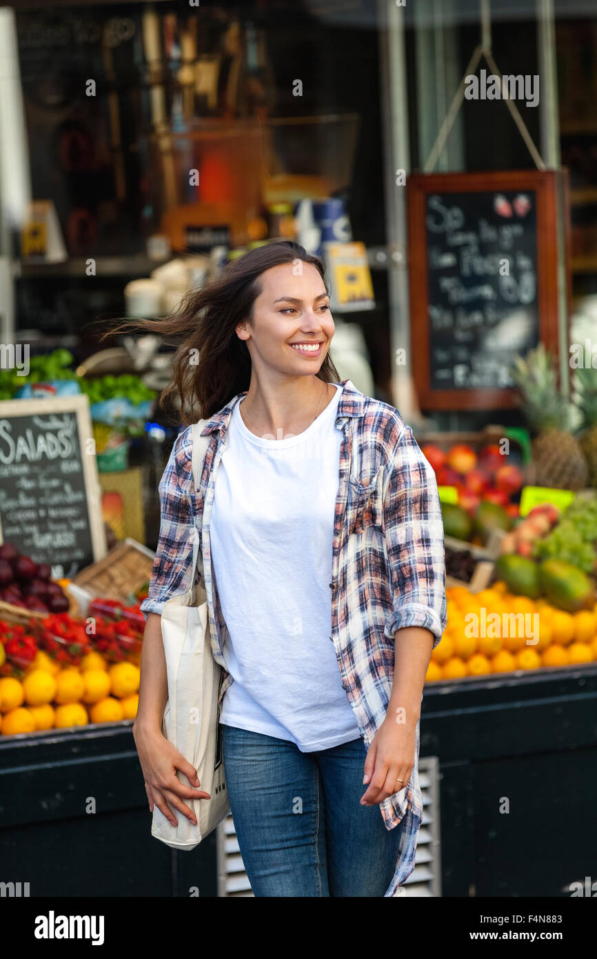Lächelnde junge Frau beim Gemüsehändler shop Stockfoto