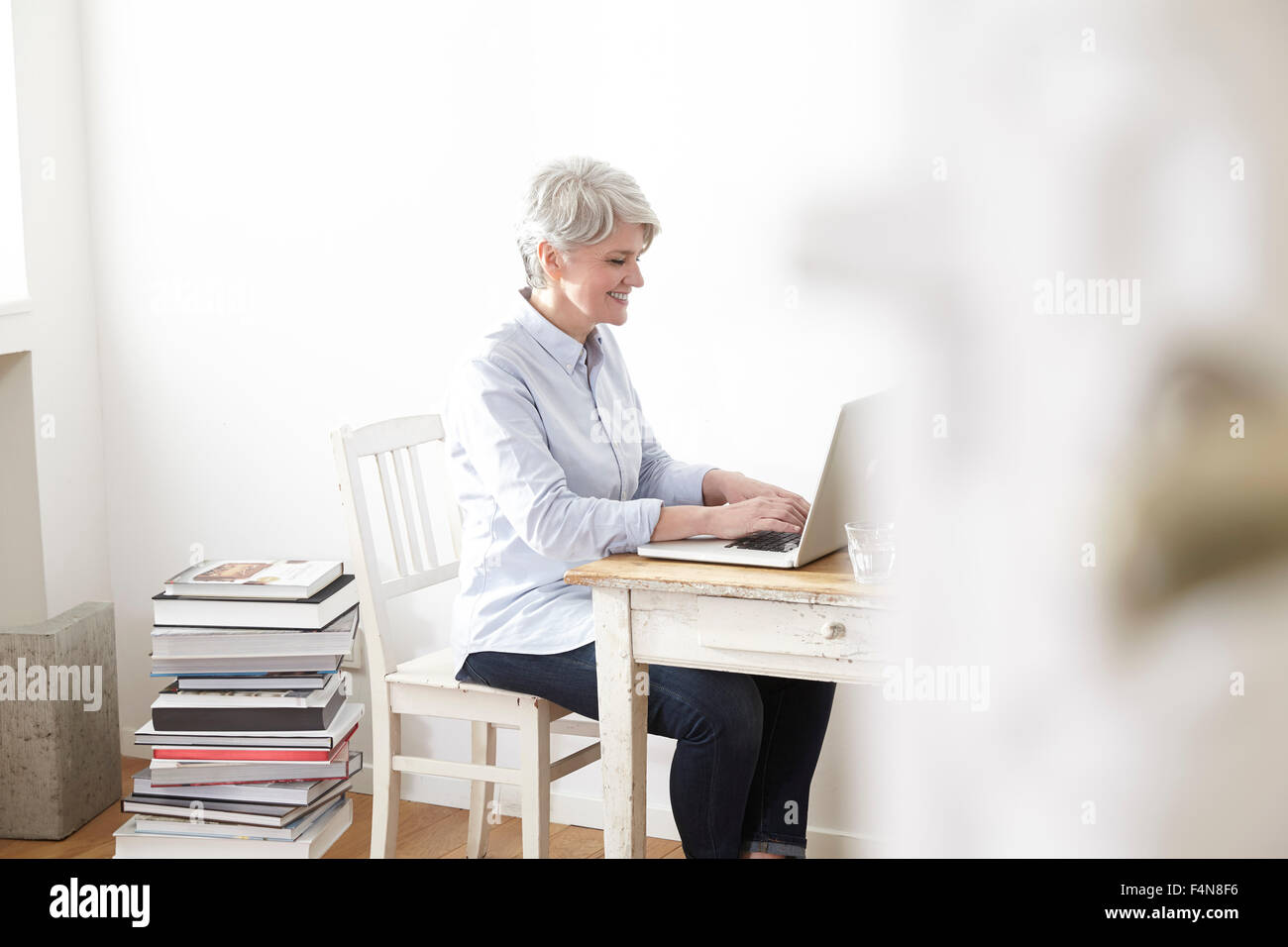 Reife Frau am Tisch mit laptop Stockfoto