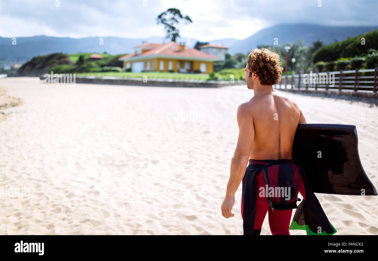 Spanien, Asturien, Colunga, Surfer mit Bodyboard zu Fuß am Strand Stockfoto