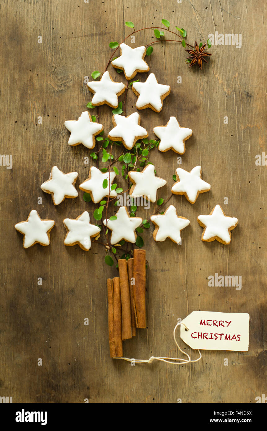 Weihnachtsbaum-Form gemacht, Zimtsterne und Stöcken auf Holz Stockfoto