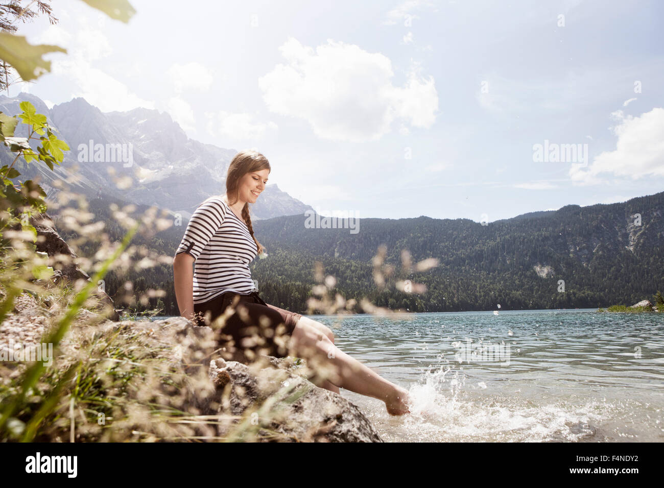 Deutschland, Bayern, Eibsee, lächelnde Frau, planschen im Wasser Stockfoto